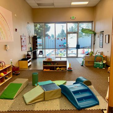 Bright and colorful indoor playroom with soft climbing structures and toys.