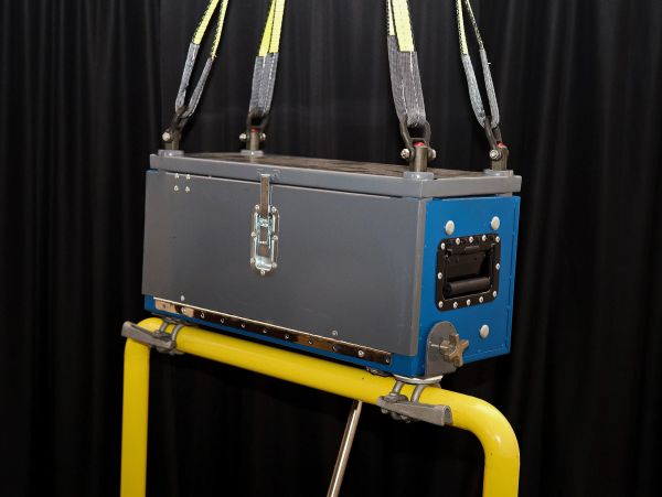 Rectangular metal box suspended by straps.