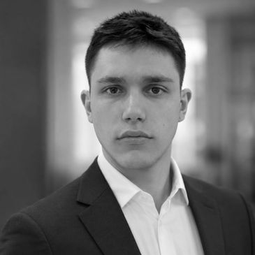 Black and white portrait of a serious young man in a suit.