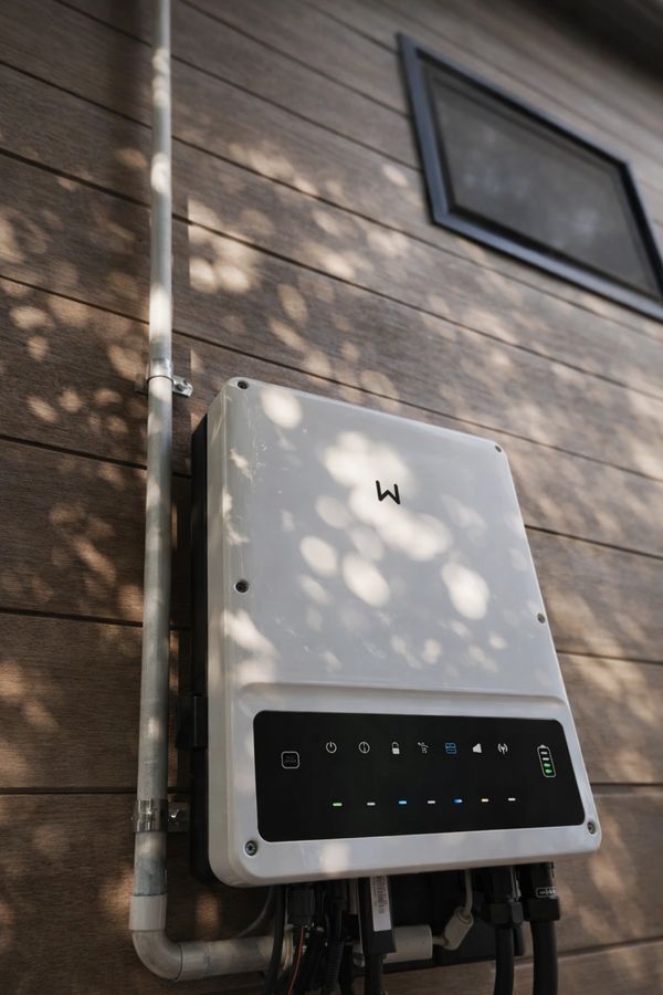 Outdoor electrical device with indicator lights mounted on wooden wall.