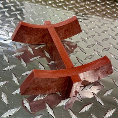 Brown plastic tile spacers on a reflective metal surface.