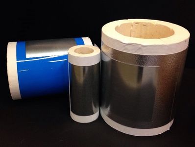 Three rolls of reflective insulation material in different sizes against a black background.