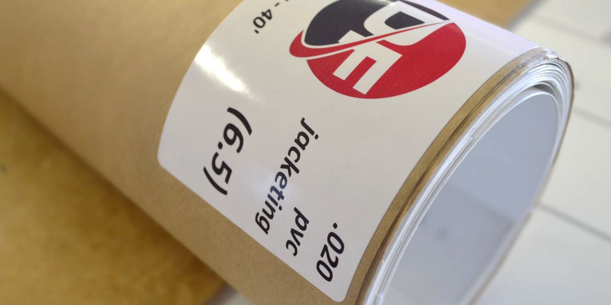 Roll of white PVC jacketing with a label and red-black logo.
