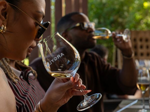 Two people savoring drinks in glassware marked 'Argyle'.