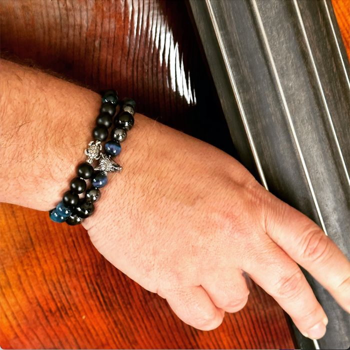 A bass player wearing two Willow Stray custom bracelets.