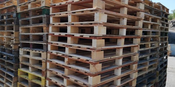 Recycled, wooden, standard pallets stacked outside
