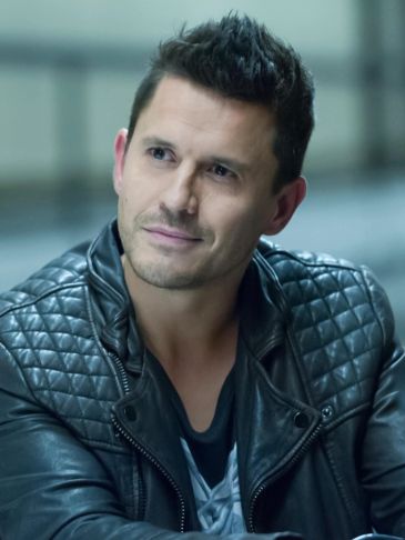 Man in a black leather jacket looking to the side.