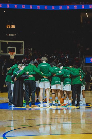 Basketball team huddling together before the game.