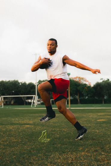 Athlete jumping over hurdle during training.