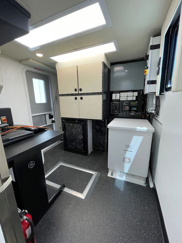 Interior of a clean, modern utility room with cabinets and control panels.