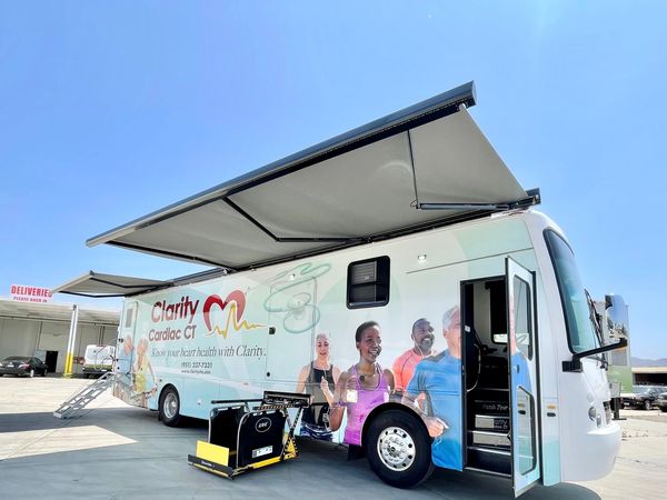 Mobile cardiac CT unit with extended awnings on a sunny day.