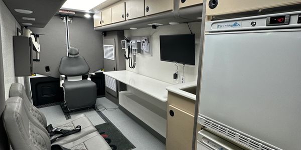 Interior of a modern medical or mobile office with seating and equipment.