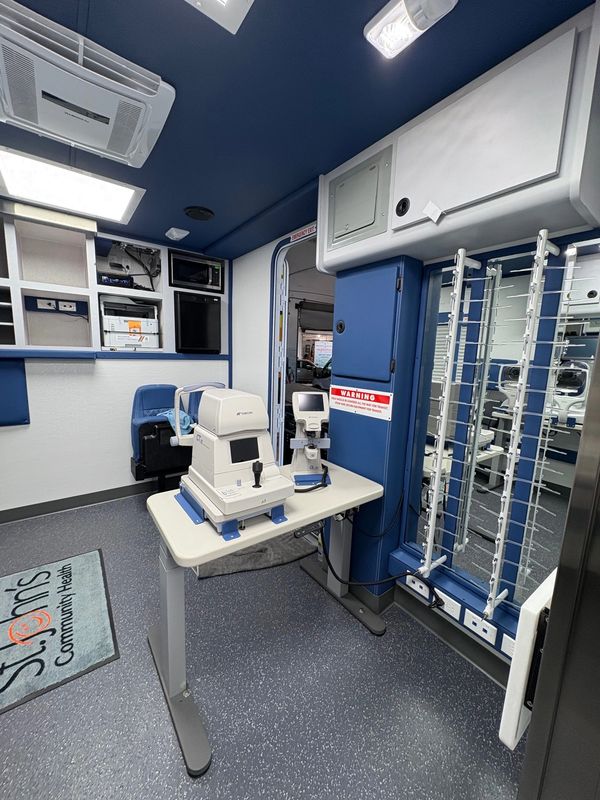 Interior of a mobile eye clinic with ophthalmic equipment and eye testing devices.