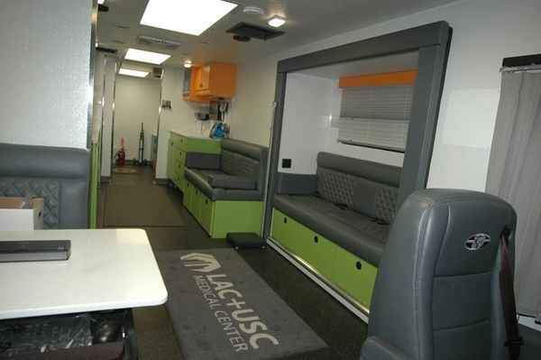 Interior of a mobile medical unit with seating and medical equipment.