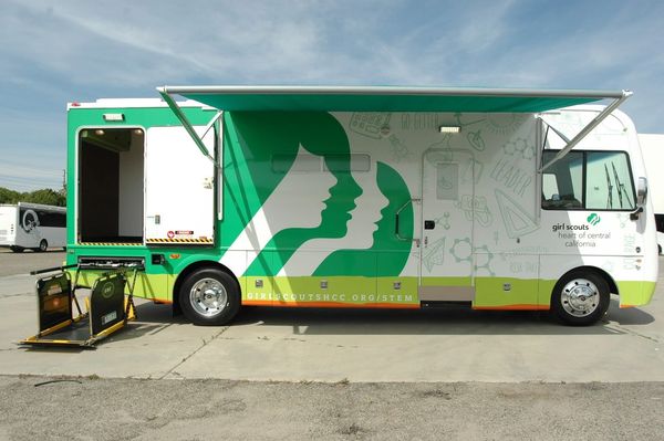 Mobile Girl Scouts STEM learning vehicle with green and white design.