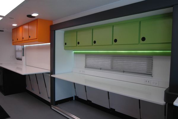 Modern workspace with colorful overhead storage and LED lighting.
