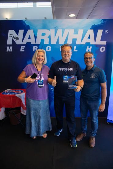 Três pessoas sorrindo em evento da Narwhal Mergulho.