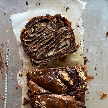 Chocolate swirl bread loaf sliced on parchment paper.