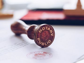A wooden notary public stamp on a document.