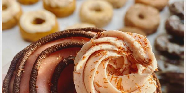 Close up of a strawberry covered chocolate swirl cake donut. Always gluten free and nut free.