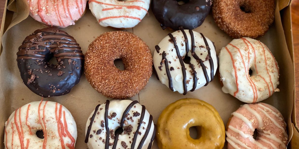 Box of donuts, incl chocolate covered, cinnamon & sugar or vanilla (white) icing and strawberry.