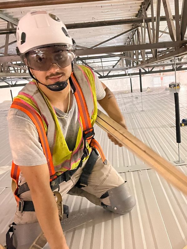 Construction worker wearing safety gear inside a building under construction.