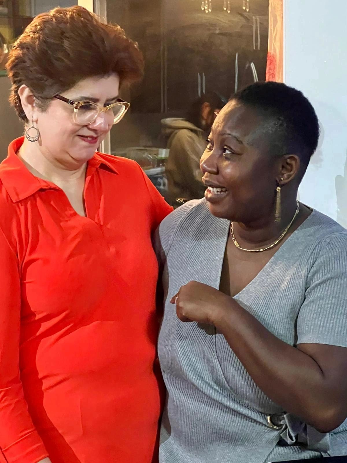 Two women sharing a joyful moment indoors.