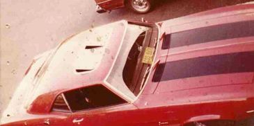 '69 camaro sitting in a parking lot