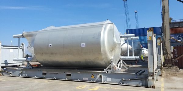 Large industrial metal tanks on a loading platform outdoors.