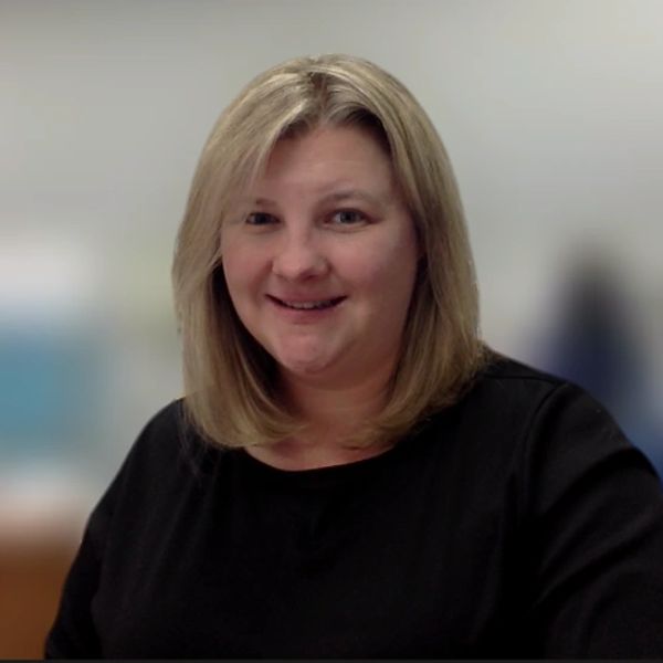 Smiling woman with blonde hair in a black top.
