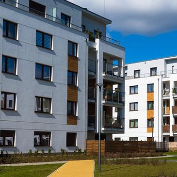 Modern apartment buildings with balconies and a yellow walkway.