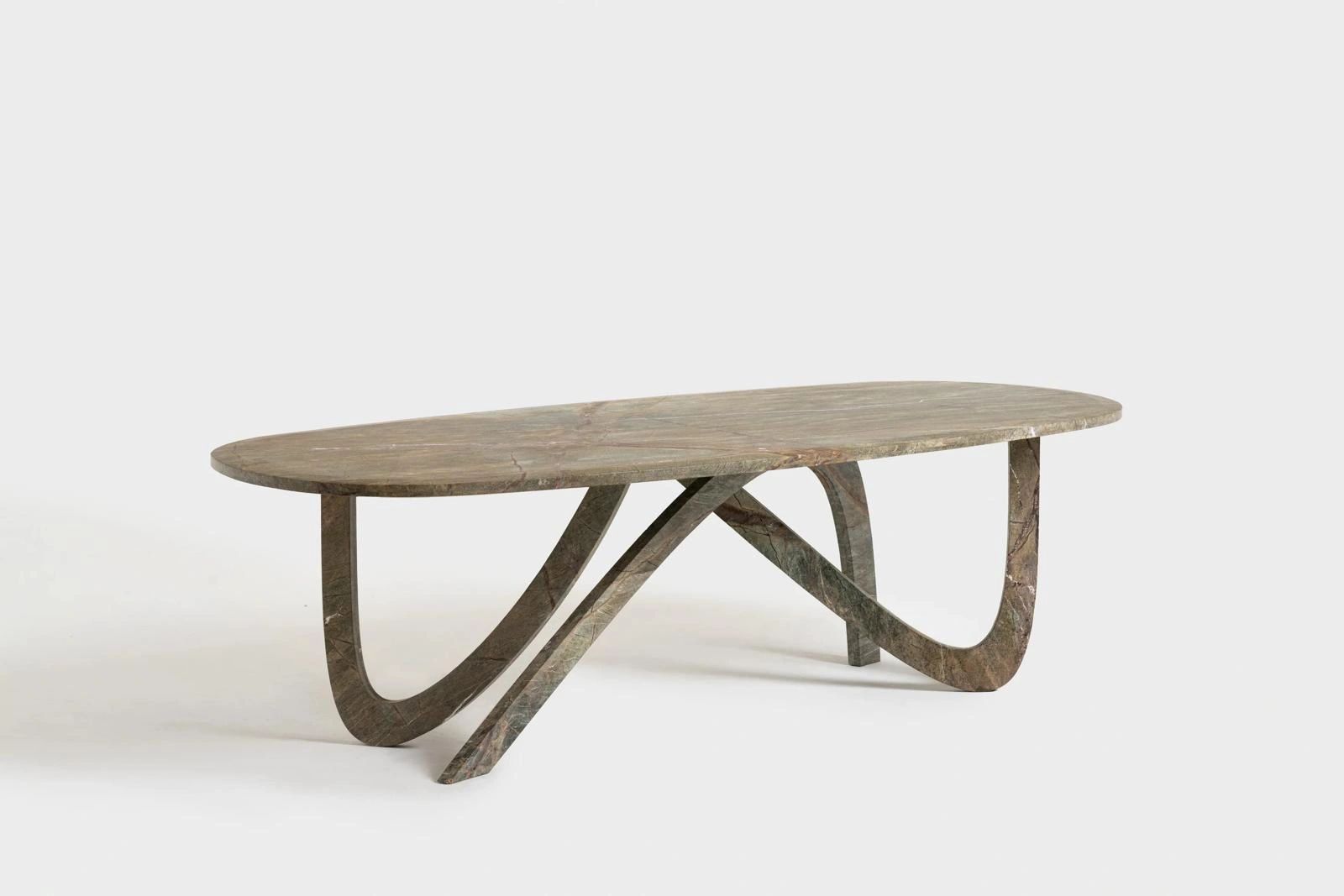 Modern stone coffee table with an oval top and sculptural curved legs.