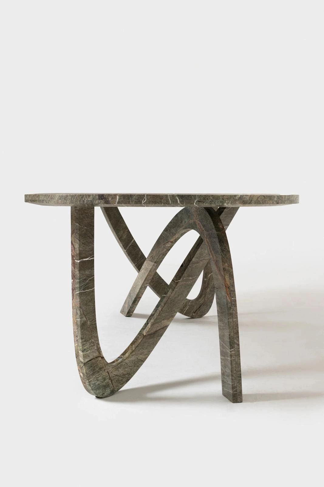 Modern round marble table with artistic curved legs.
