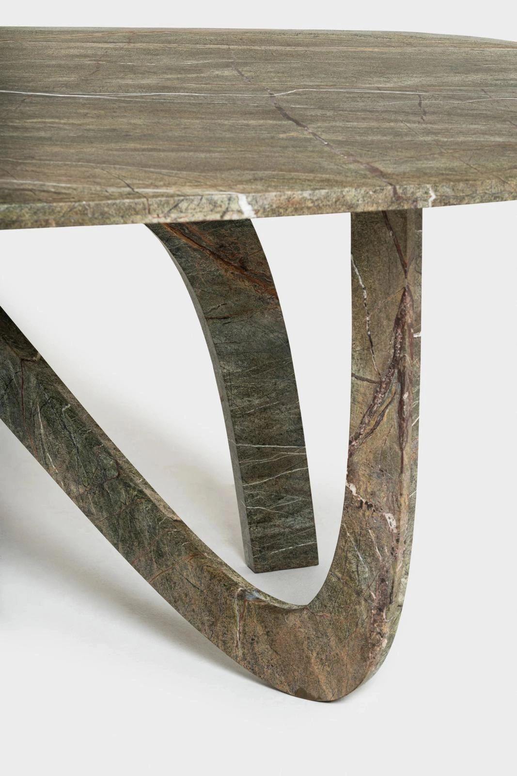 Close-up of a marble table with unique curved legs and natural veining.