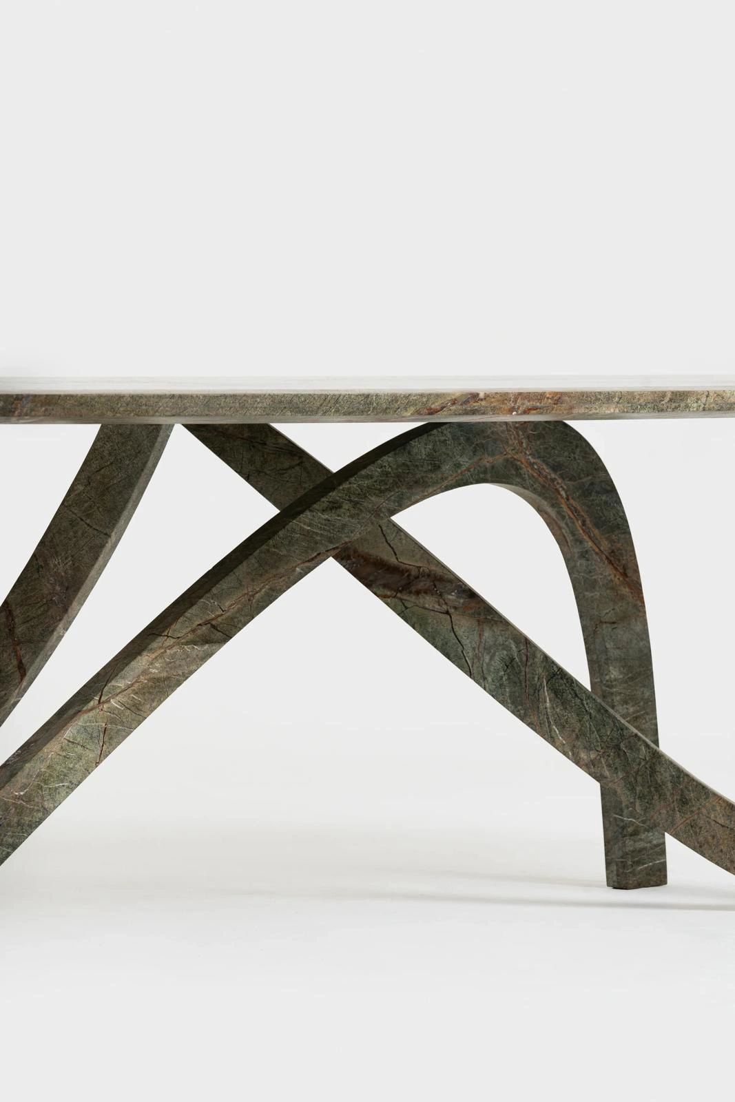 Modern stone table with unique curved legs.