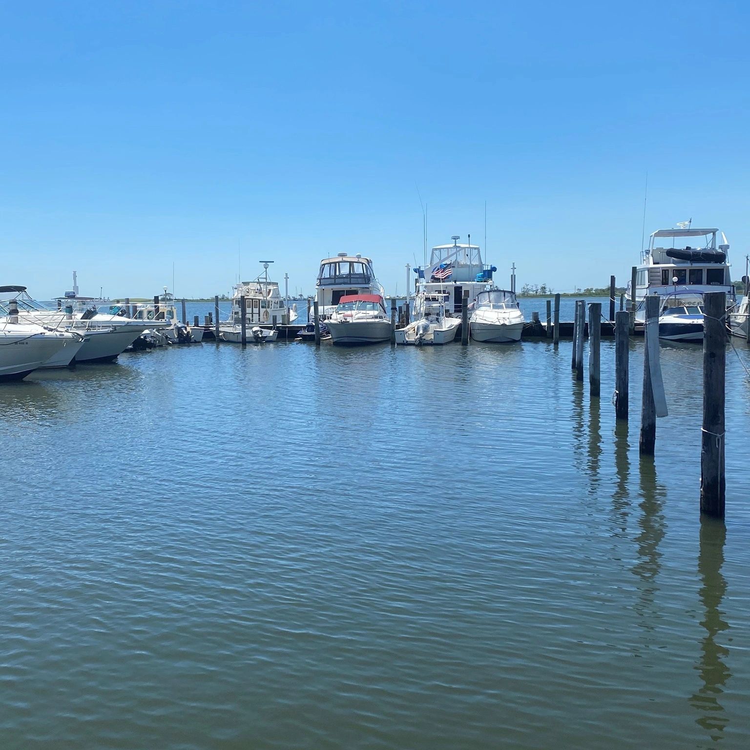 Boats docked peacefully at Nauti River Marina under a clear blue sky.
