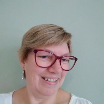 Smiling person wearing red glasses.