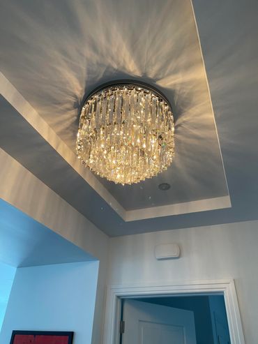 Elegant crystal chandelier casting beautiful light patterns on the ceiling.