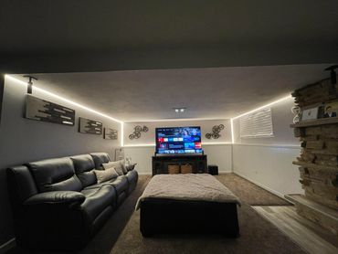 Cozy home theater room with large TV and sectional sofa.