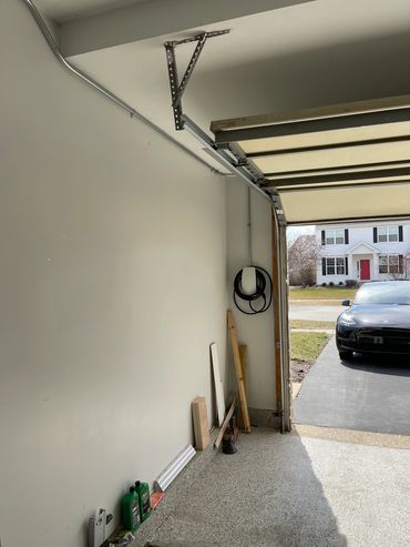 Interior view of a garage with tools and a car outside.