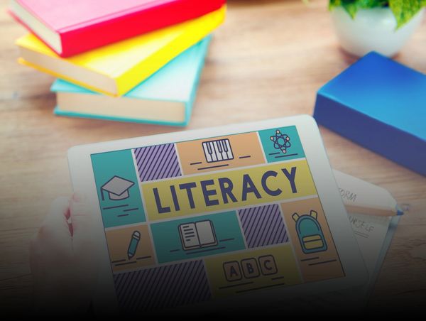 wooden table with books and a tablet with literacy written on it 3