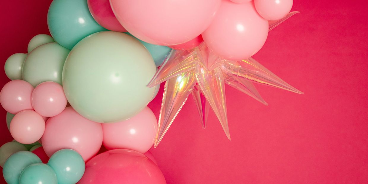 Pink, mint green, teal, and hot pink balloon garland with iridescent starbursts