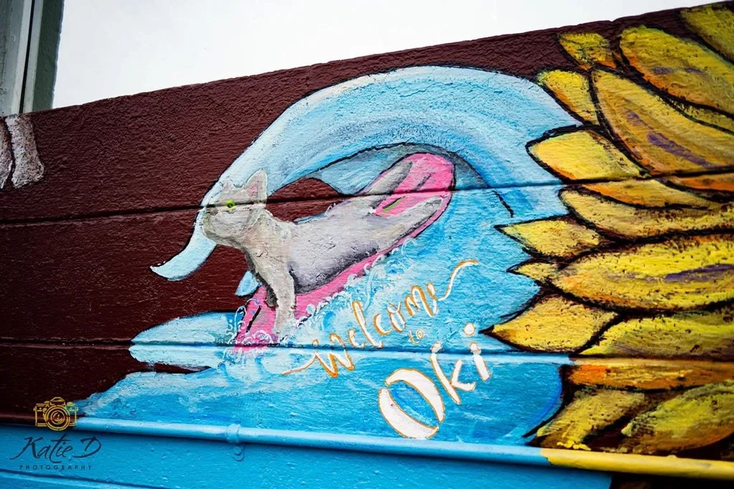 Welcome to Oak Island North Carolina surfing dog mural art at Grape and Ale.  Artist by JT Mariotte