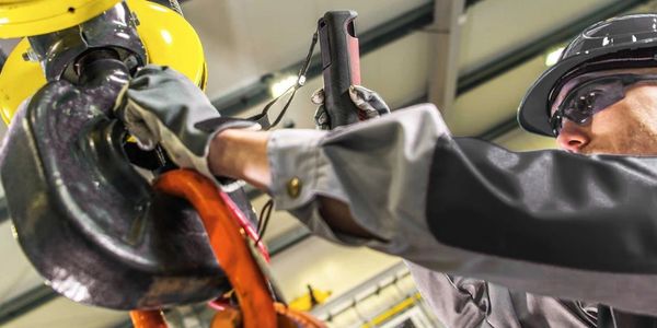 Worker in safety gear operating a heavy-duty industrial hook.