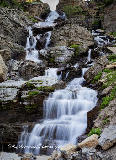 A serene multi-tiered waterfall cascading down rocky terrain.