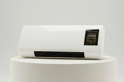 A white electric heater with digital controls on a pedestal.