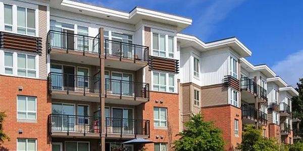 Modern multi-story apartment building under blue sky.