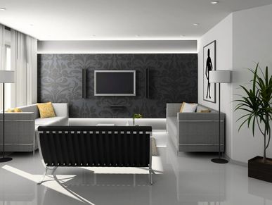 Modern living room with gray sofas and patterned dark accent wall.