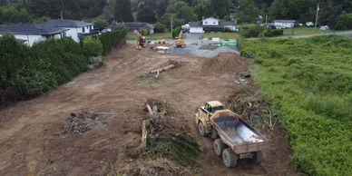 Construction site with a dump truck and dirt piles.