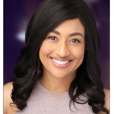 Smiling woman with dark hair and a light top.